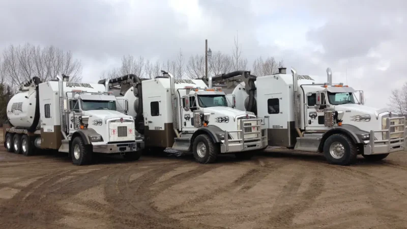 Fleet of parked white hydrovac trucks with Rippin Edge branding