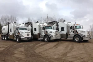 Fleet of parked white hydrovac trucks with Rippin Edge branding